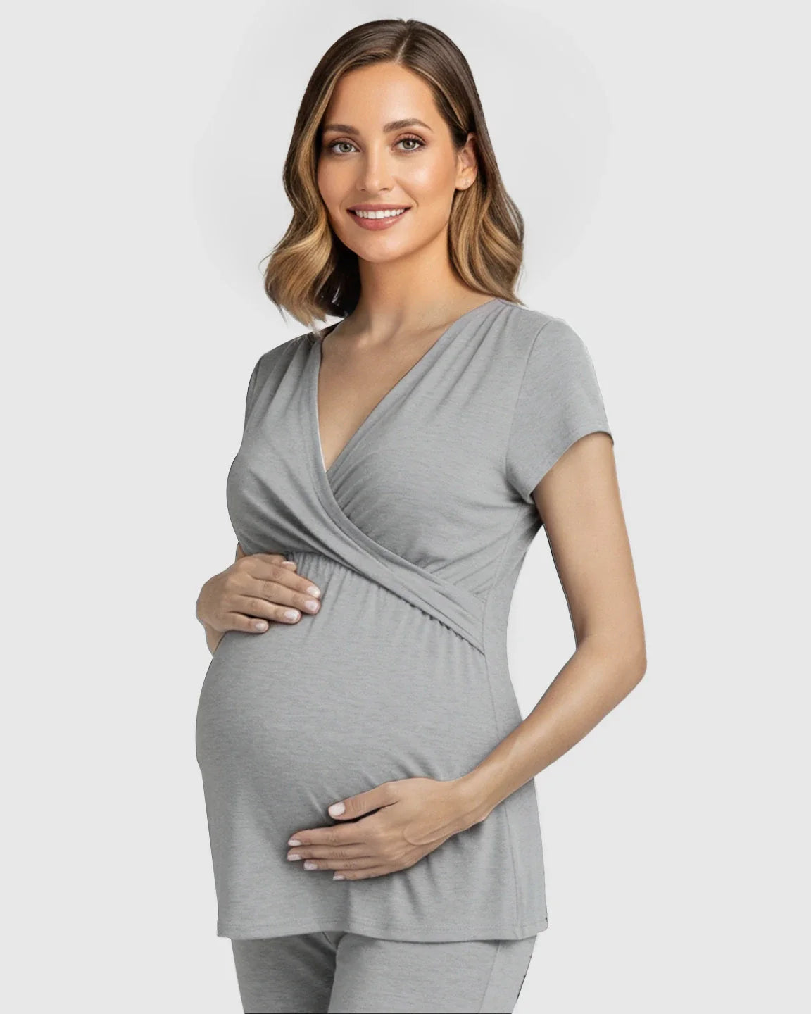 Smiling pregnant woman in a gray wrap V-neck short-sleeve maternity and nursing sleepwear top.
