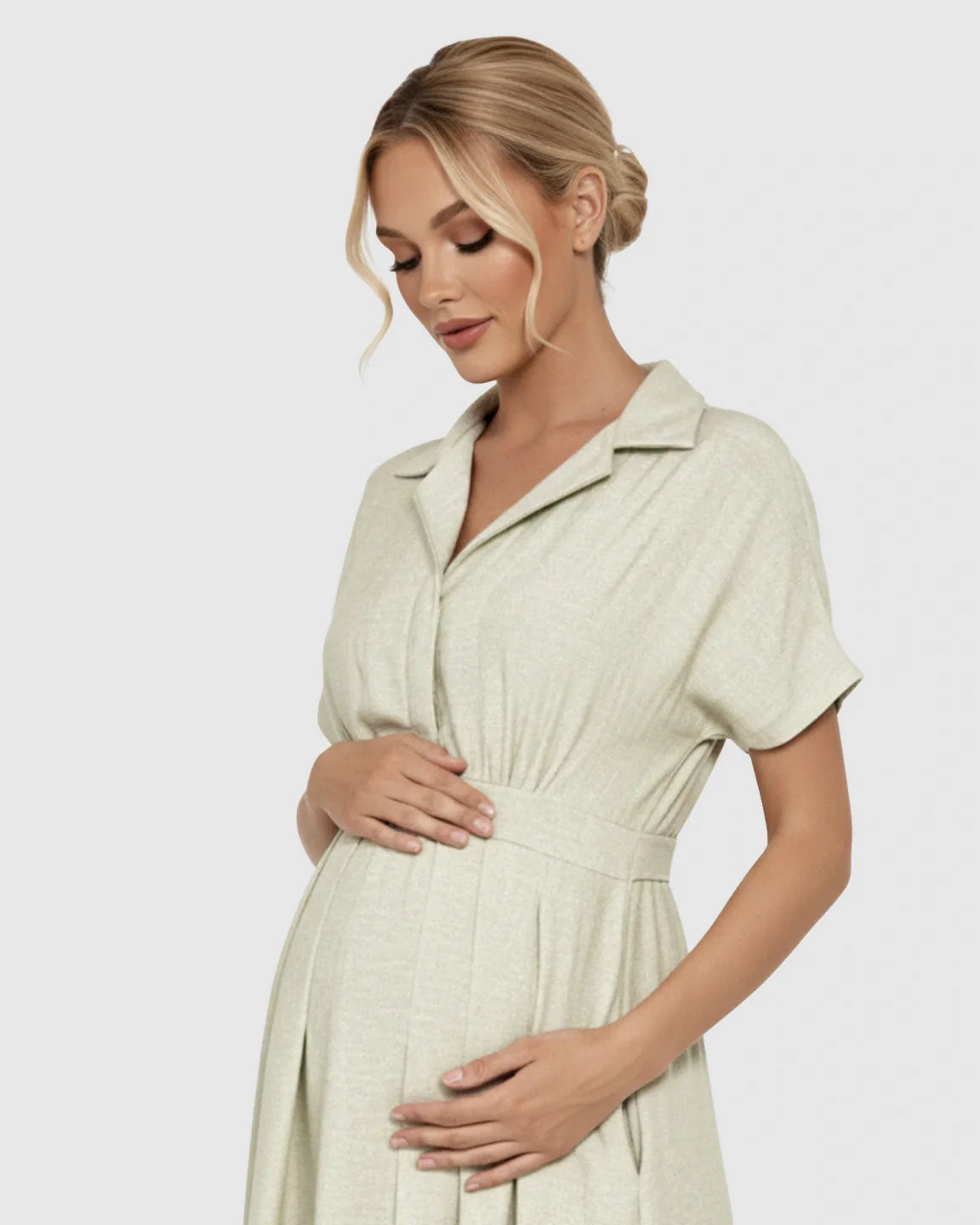 Pregnant woman in a light green lapel collar A-line maternity midi dress, holding her bump.