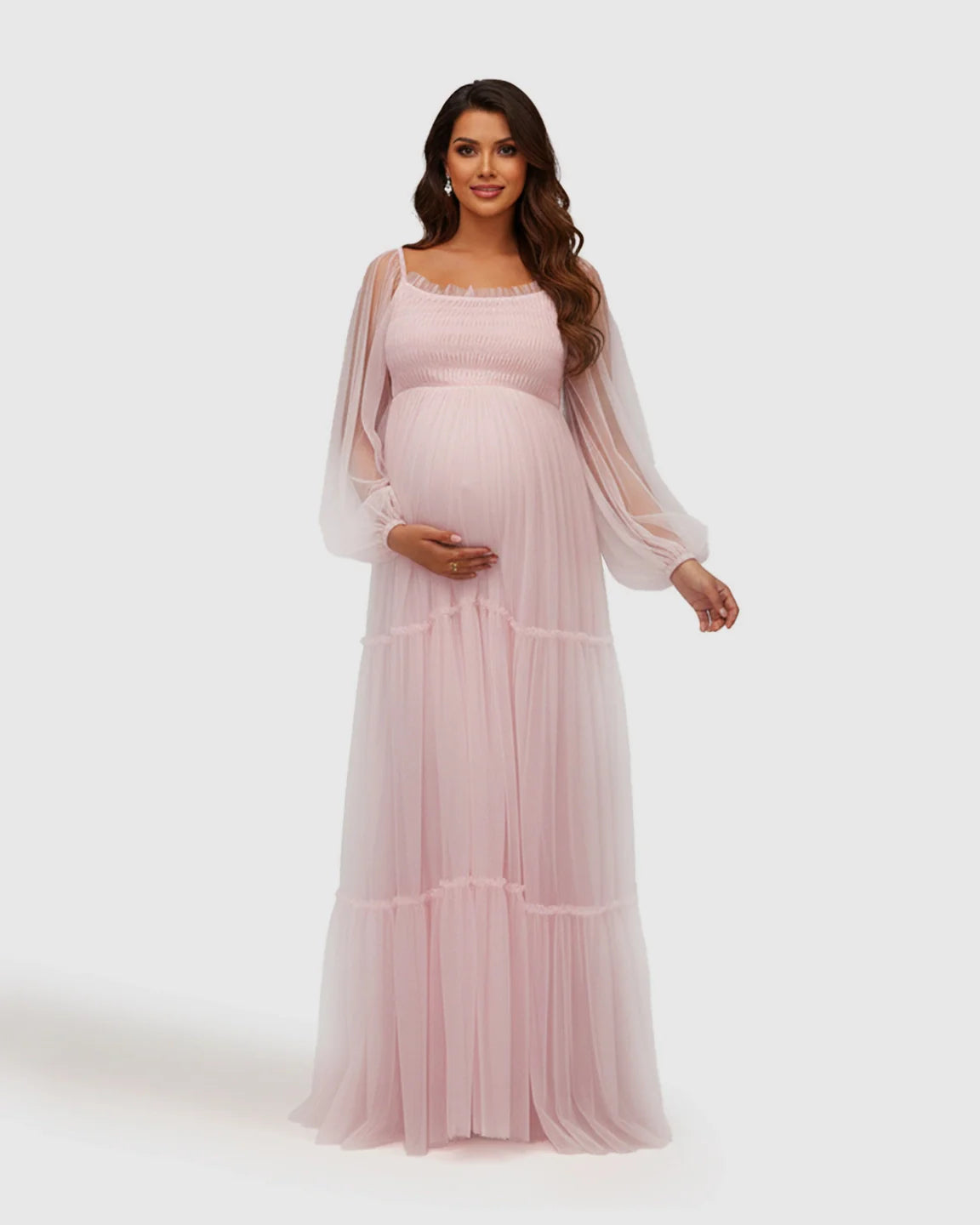 Pregnant woman in a pink tiered tulle maternity gown with lantern sleeves and a smocked bodice.