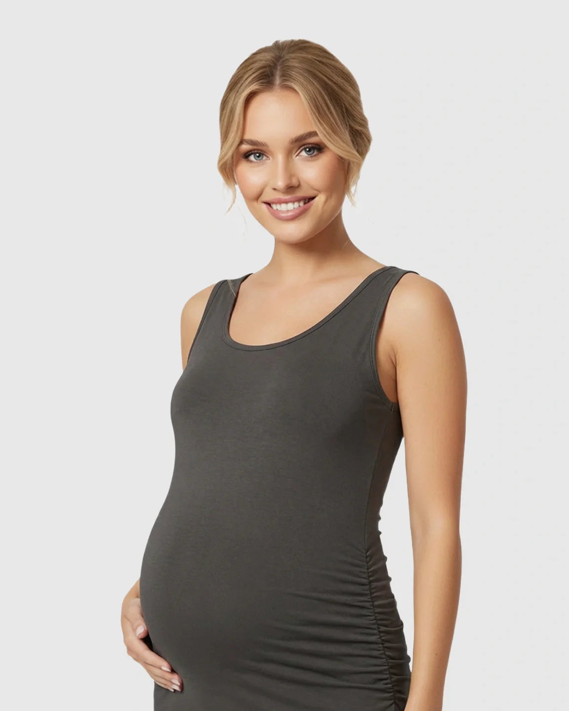 Smiling pregnant woman in a dark grey sleeveless bodycon maternity dress with side pleats.
