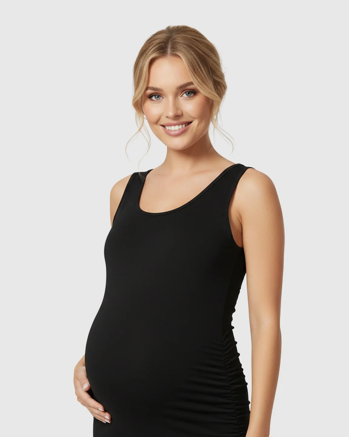 Smiling pregnant woman in a black sleeveless bodycon maternity dress with side ruching.