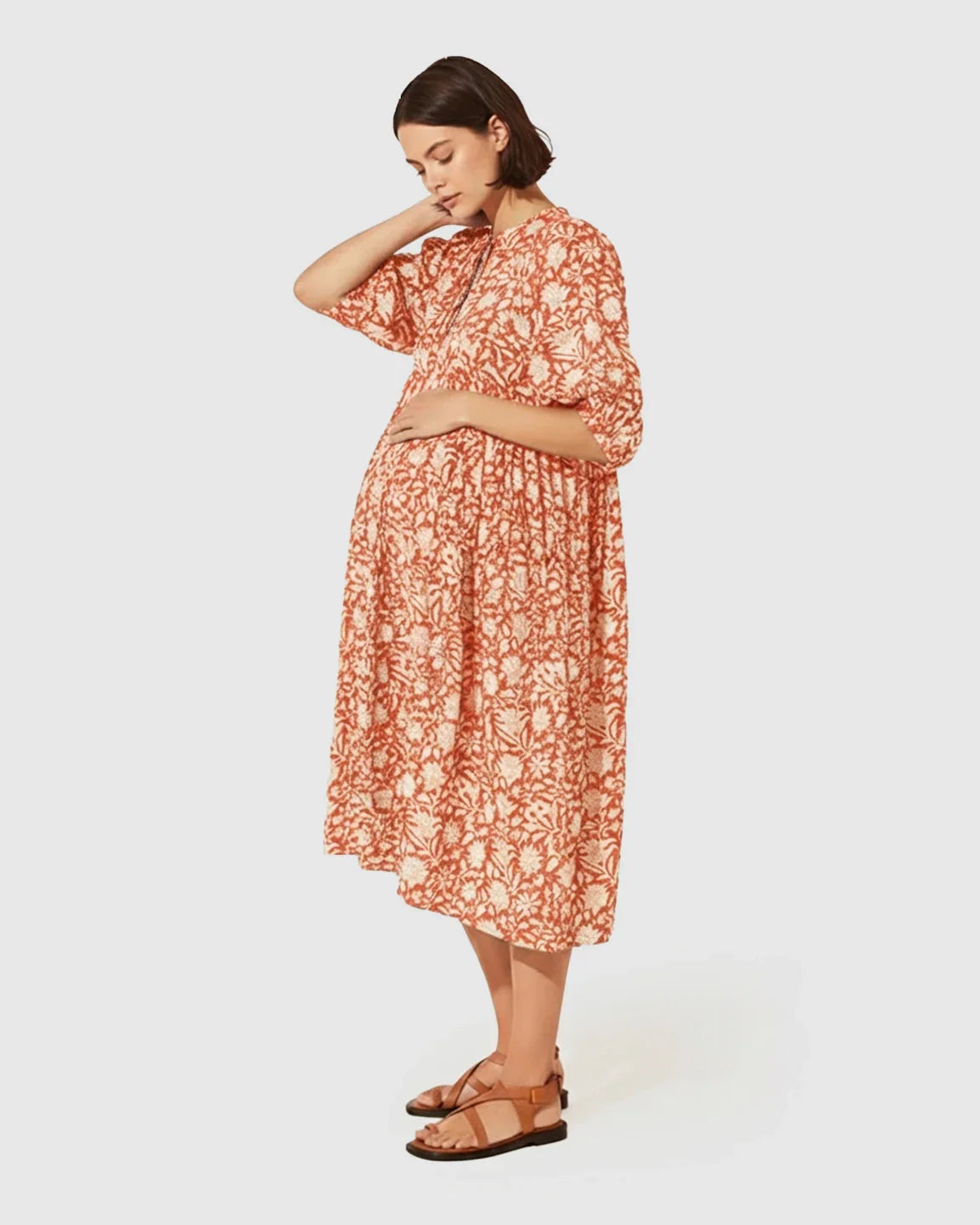 Maternity midi dress in terracotta floral print with gathered shoulders, puff sleeves, and knot detail.
