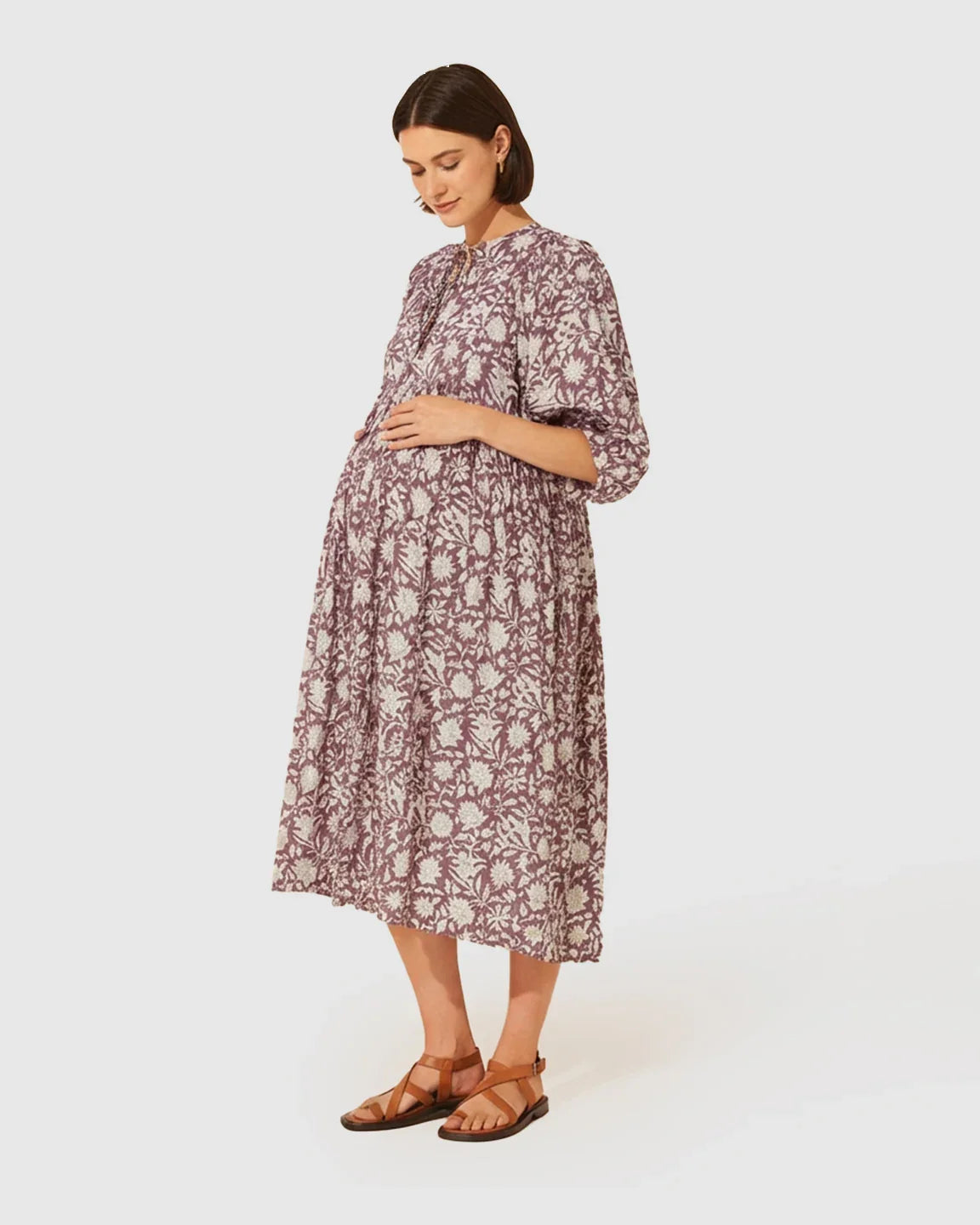Maternity midi dress in purple and white floral print with gathered shoulders, puff sleeves, and knot detail.