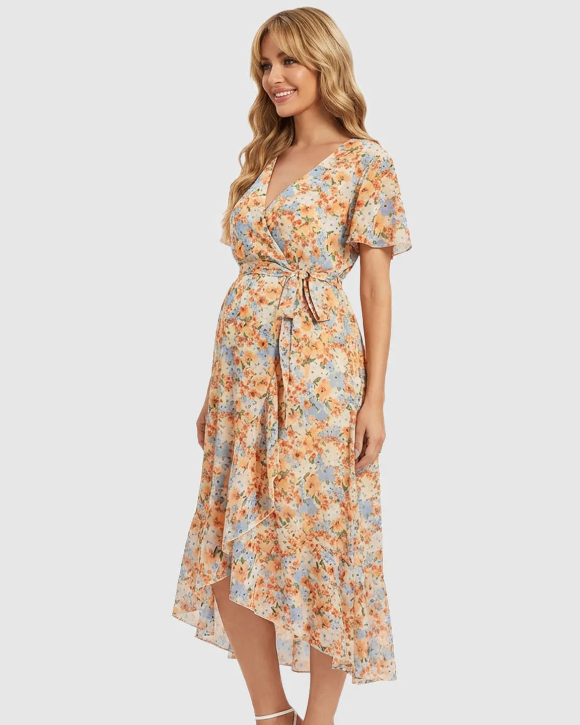 Smiling pregnant woman in a floral V-neck ruffled hem maternity midi dress with a tie waist.