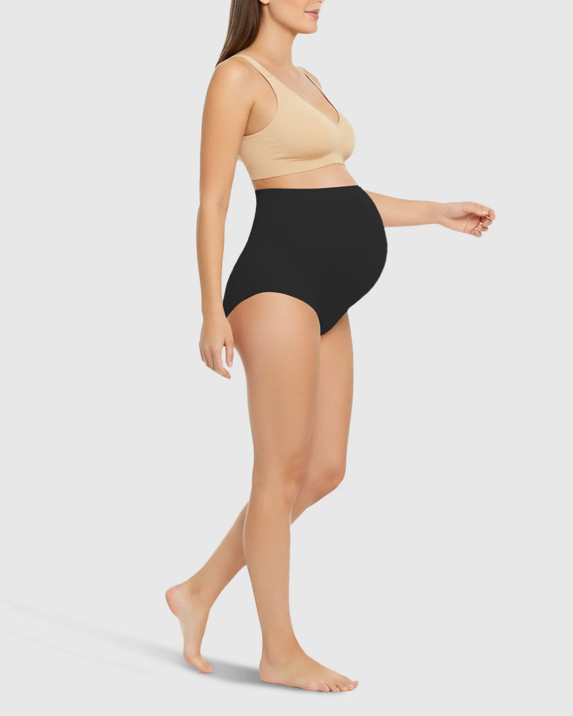 Woman in black high-waist seamless maternity underwear with belly support, paired with a beige bra.