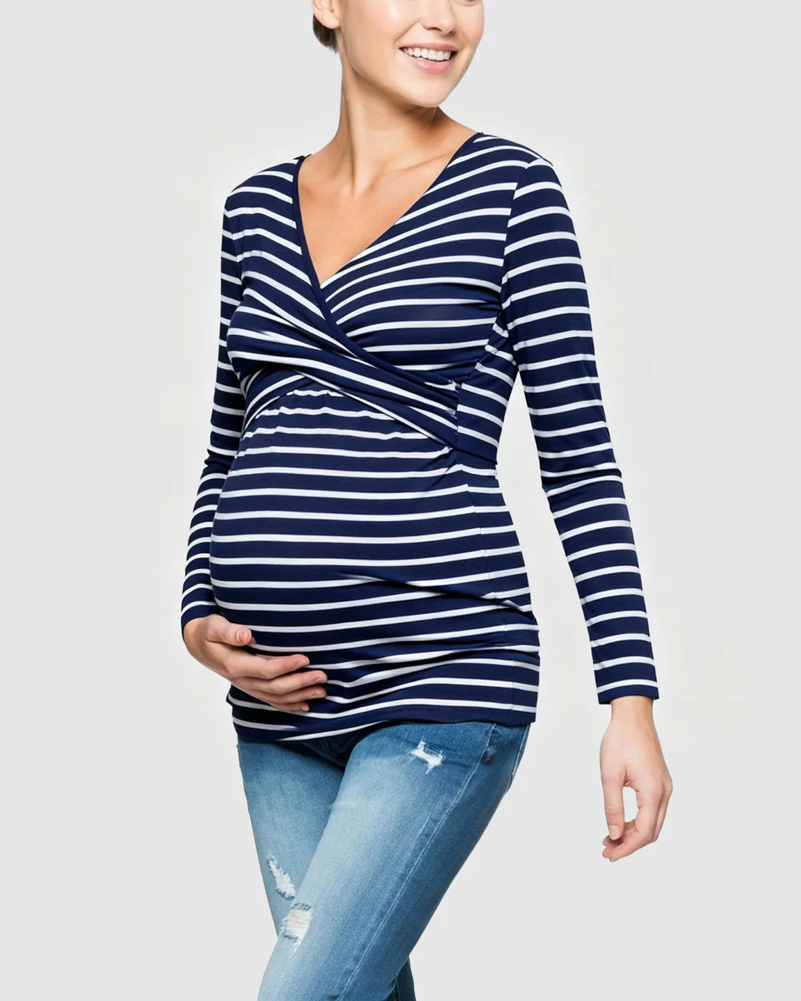 Smiling pregnant woman in a navy and white striped long-sleeve V-neck wrap maternity and nursing shirt.