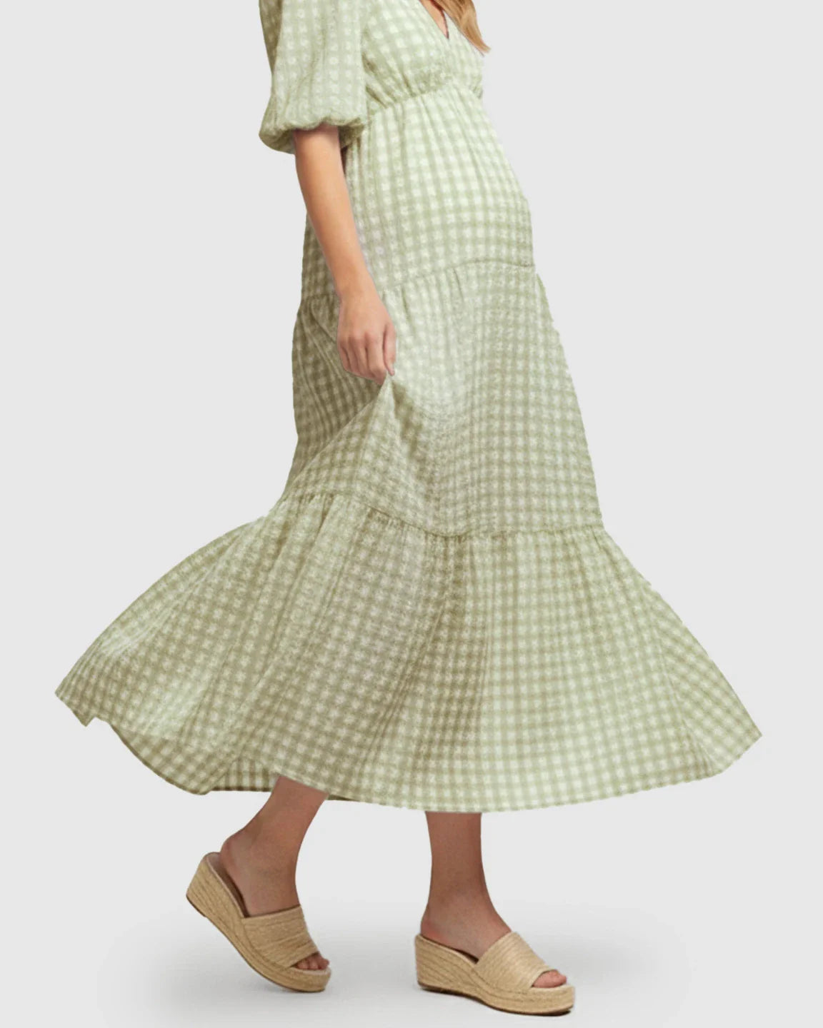 Green checkered maternity maxi dress with puffed sleeves and tiered skirt, worn with espadrille sandals.