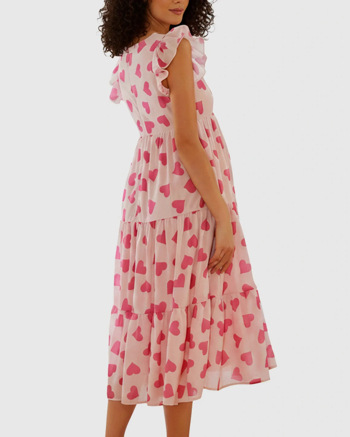 Pink chiffon maternity midi dress with tiered skirt, heart print, and flutter ruffle sleeves.