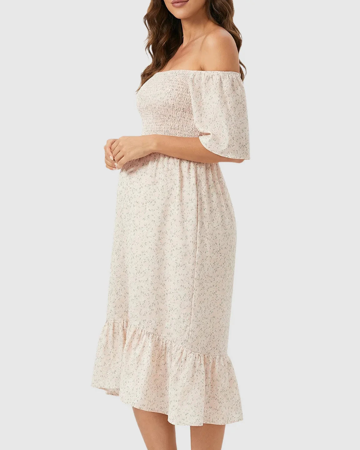 Light pink floral off-shoulder smocked maternity midi dress with flutter sleeves and tiered skirt.