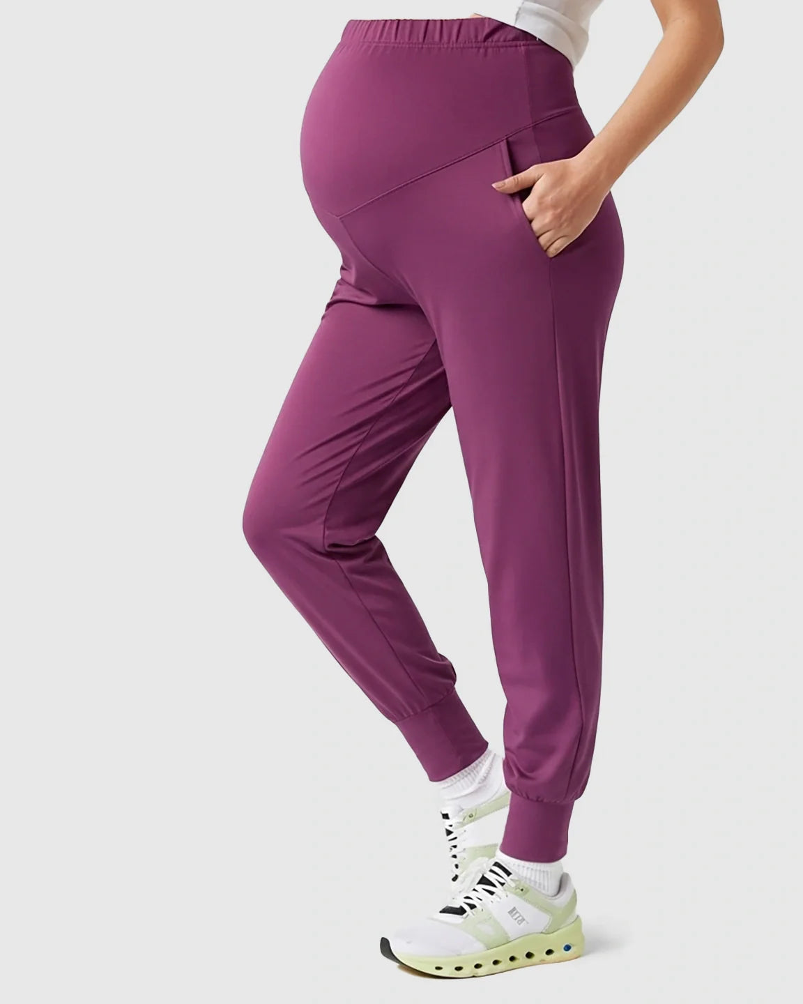 Plum supportive slim-fitting maternity joggers with high-waist belly support and side pockets.