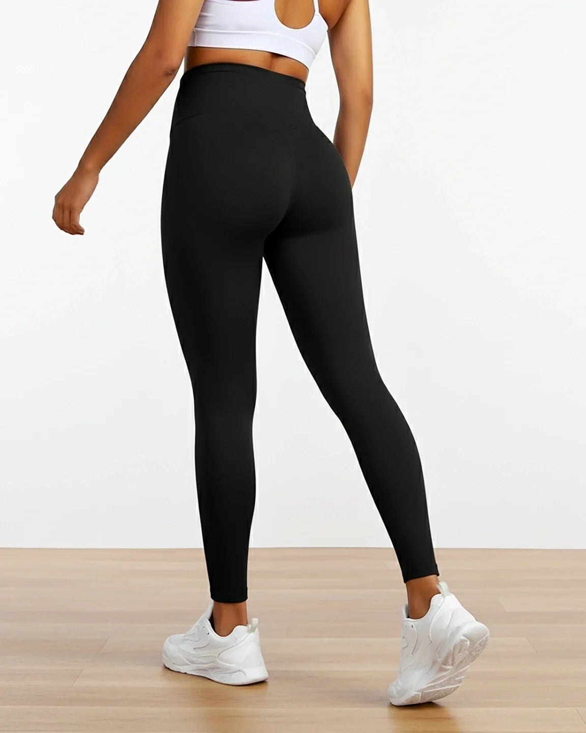 Black sculpting ankle-length maternity leggings with a high waistband, worn by a woman from behind.