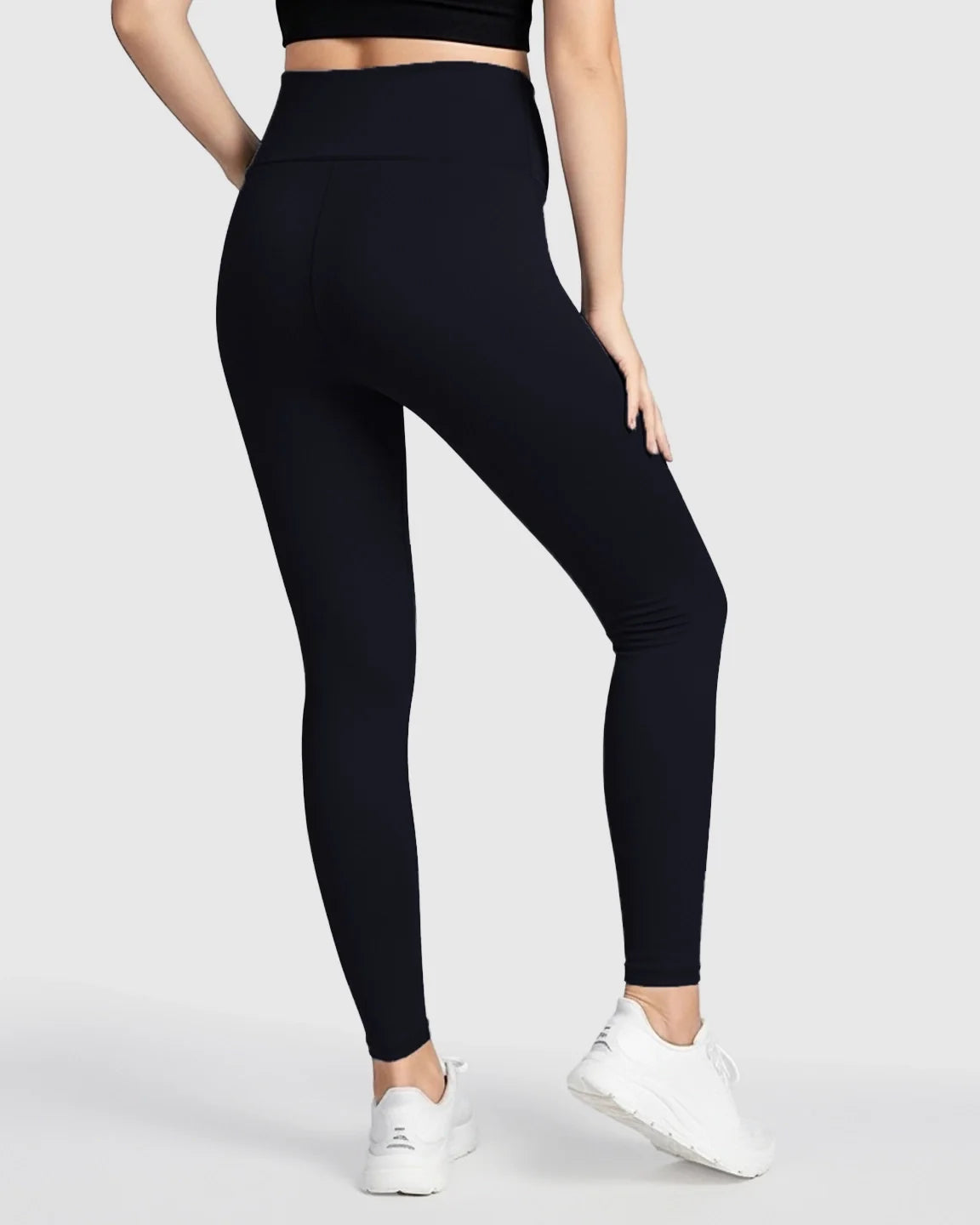 Woman from behind wearing black ultra-soft support maternity midi leggings with a seamless waistband.