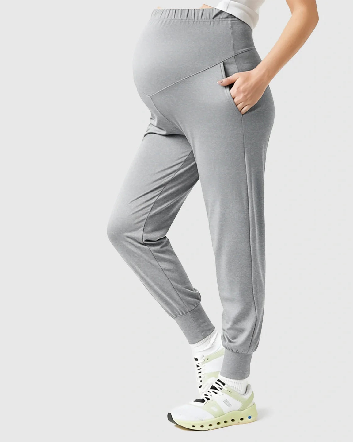 Gray supportive slim-fitting maternity joggers with high-waist design and pockets, worn by a pregnant woman.