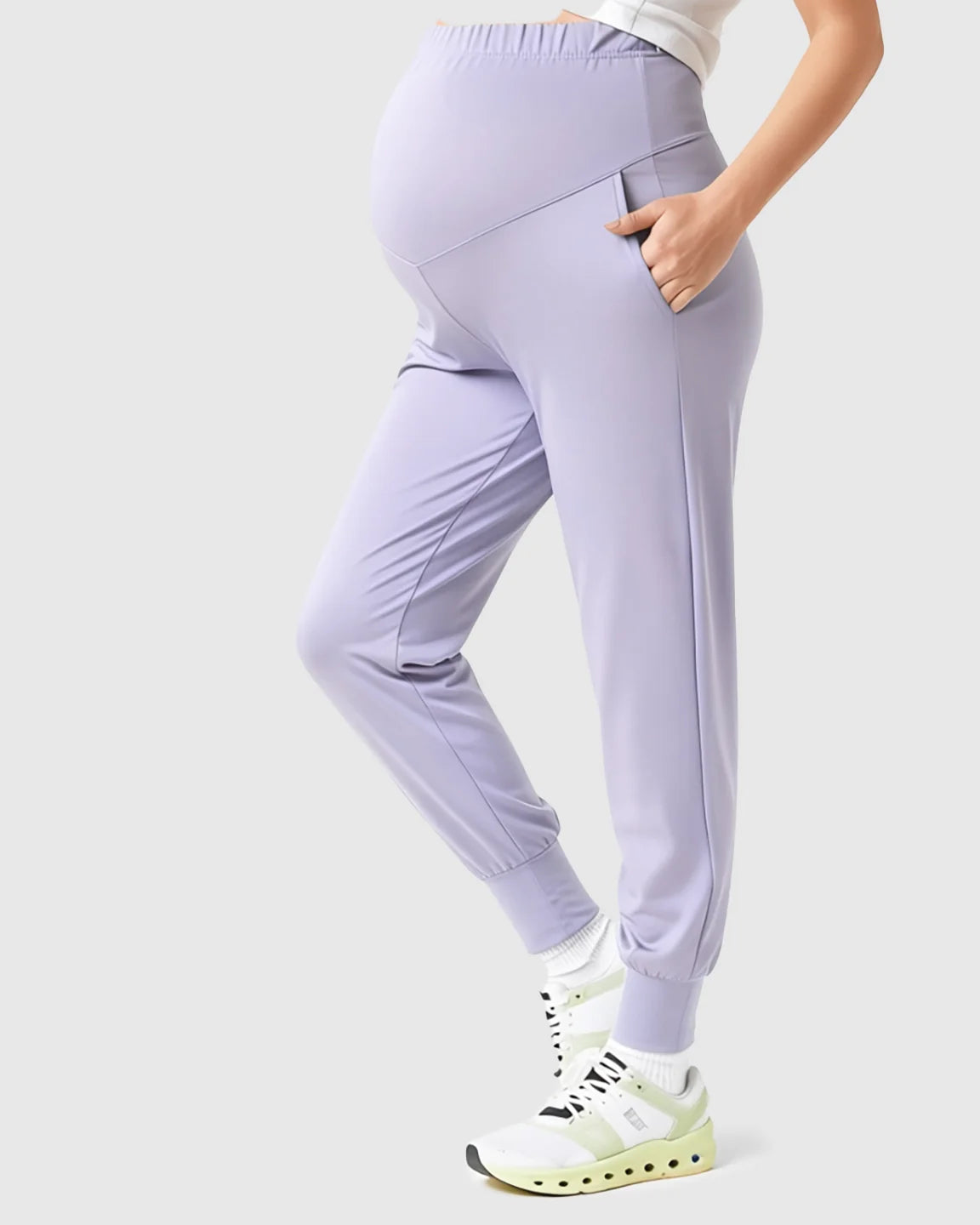 Light purple supportive slim-fitting maternity joggers with a high-waist design and pockets, worn by a pregnant model.