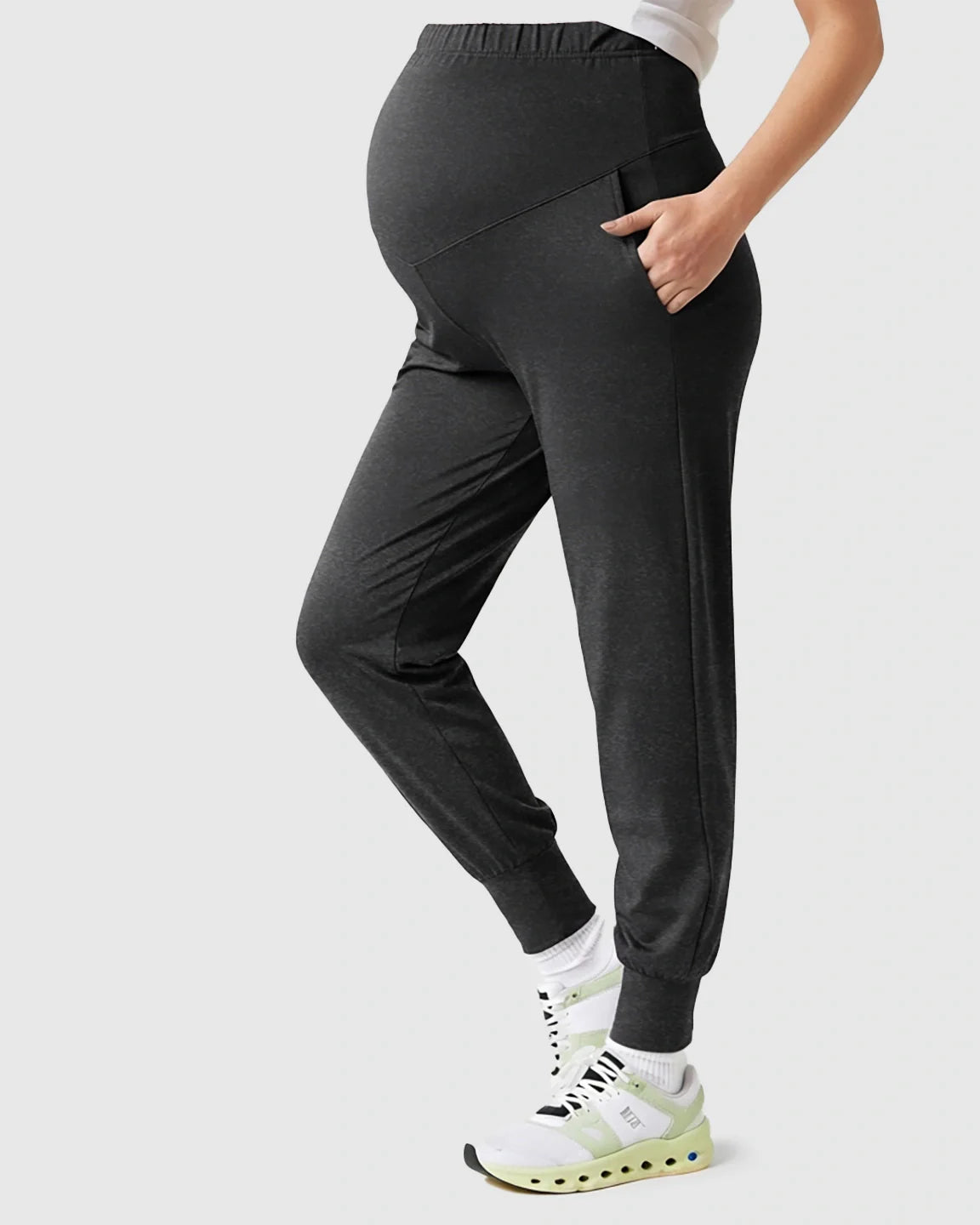 Dark gray supportive slim-fitting maternity joggers with a high-waist and pockets, worn by a pregnant woman.