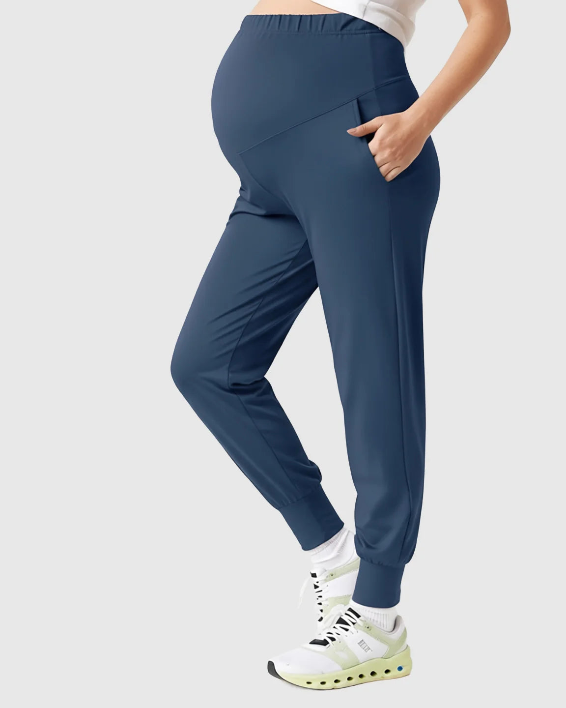 Navy blue supportive slim-fitting maternity joggers with high-waist design and side pockets.